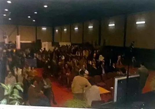 Pabellón lleno de público ante un escenario con plantas, durante el campeonato.