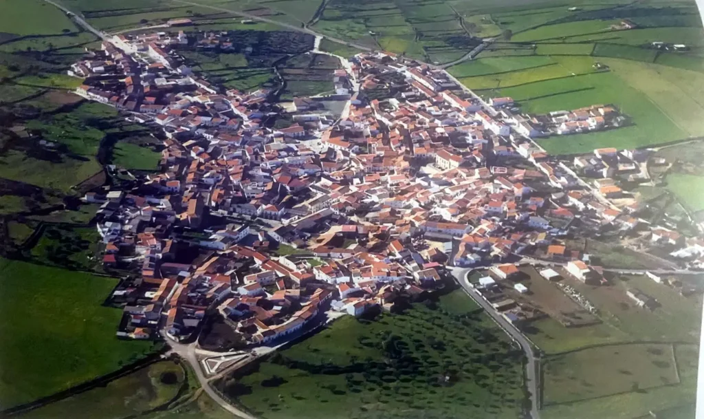 Vista aérea oblicua del casco urbano de Ibahernando: calles estrechas, tejados de teja roja y fachadas encaladas.