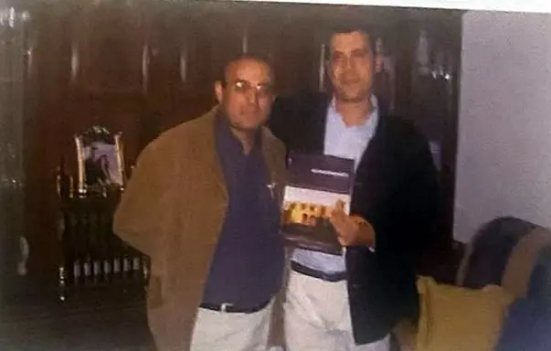 Dos hombres sostienen uno de los primeros ejemplares del libro recién impreso.